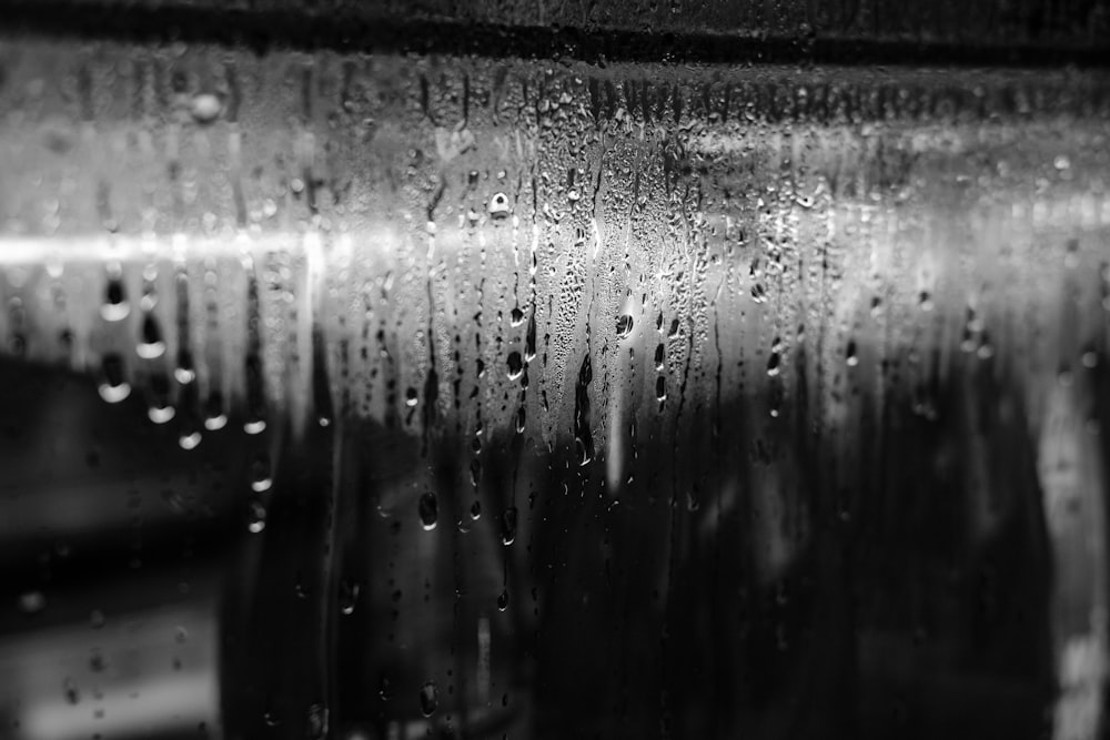 a black and white photo of rain drops on a window