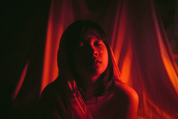 A participant meditating with eyes closed, surrounded by soft light and gentle colors.