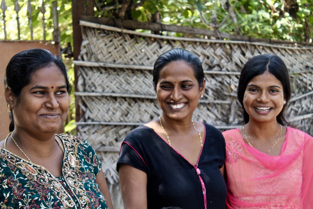 three women wearing assorted-color shirts