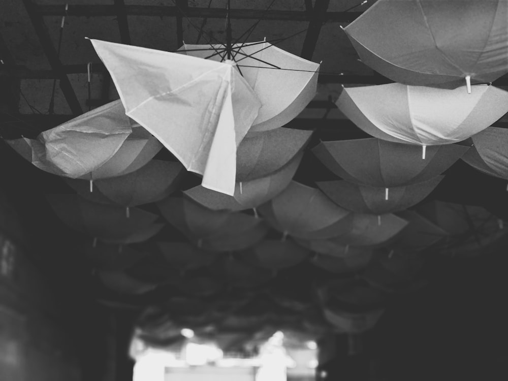 grayscale photo of pile of umbrellas