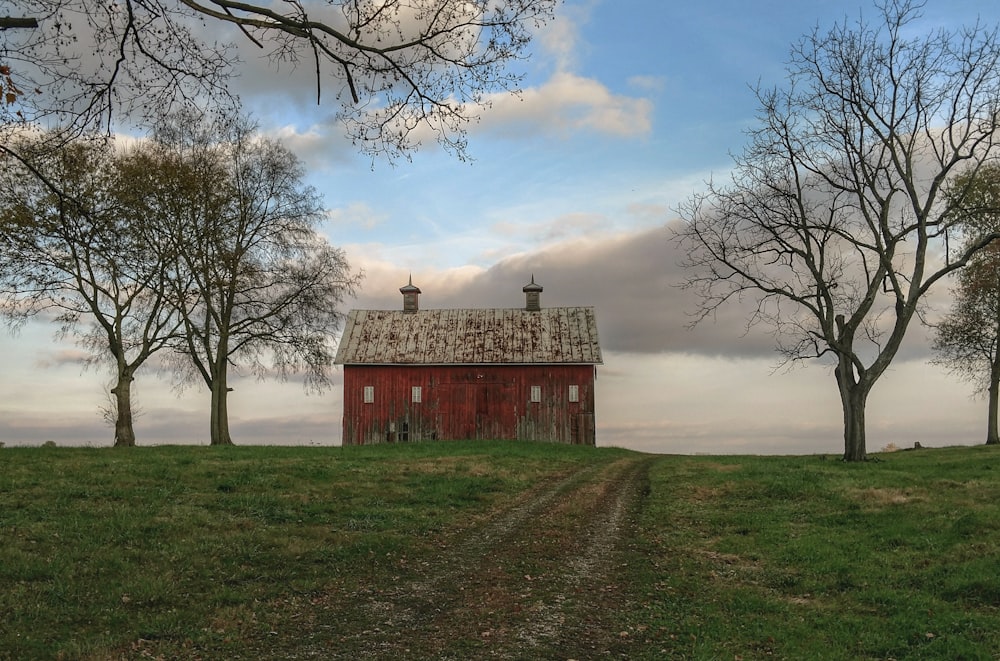 red and gray barn on green grass lawn