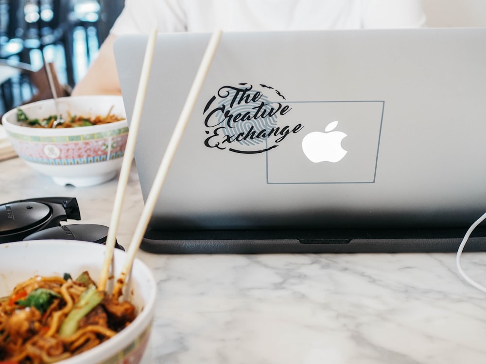 silver MacBook near white bowl