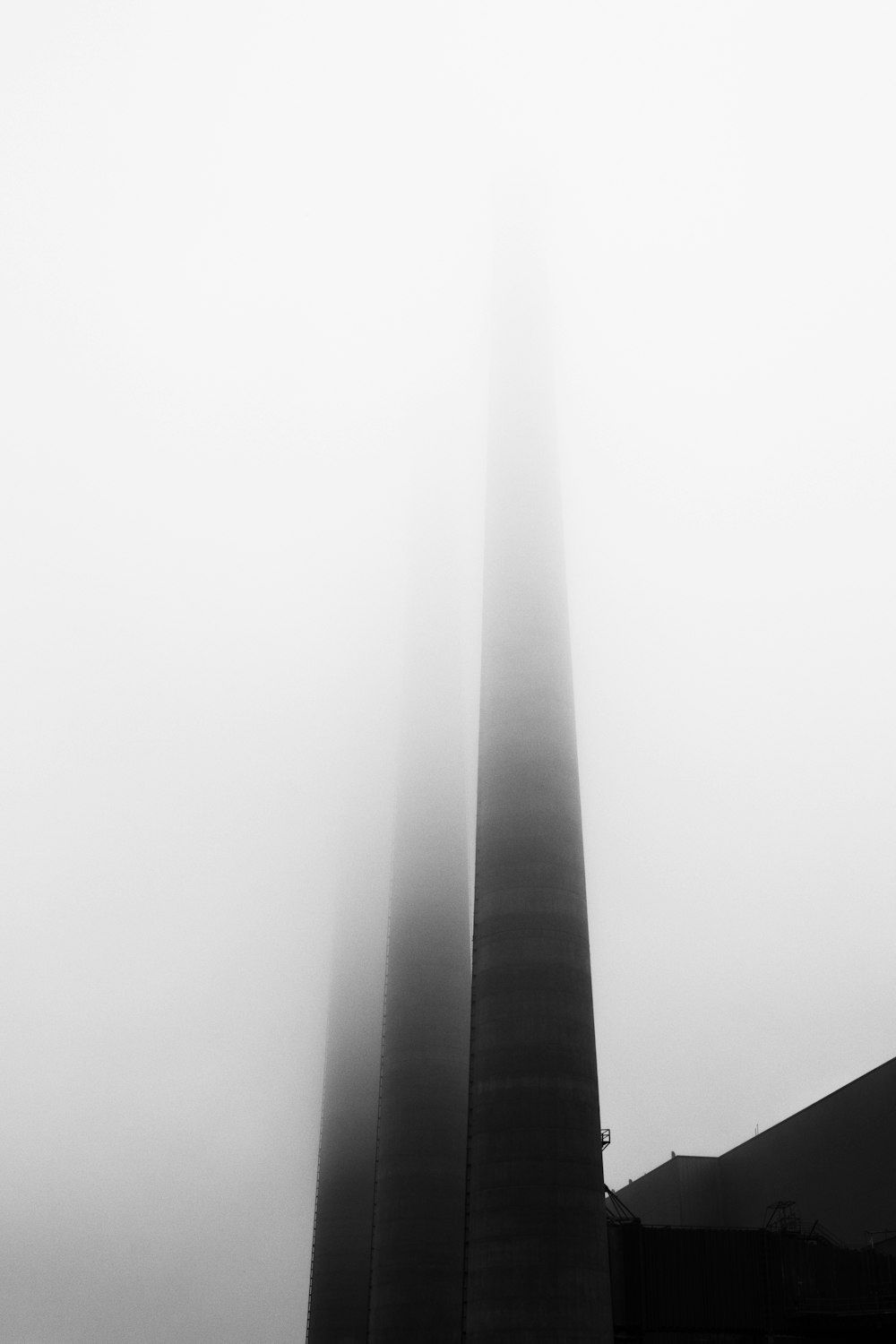 a black and white photo of the washington monument in the fog