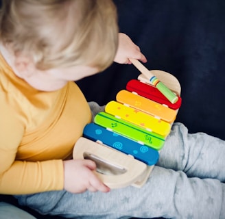 toddler playing wooden xylophone toy