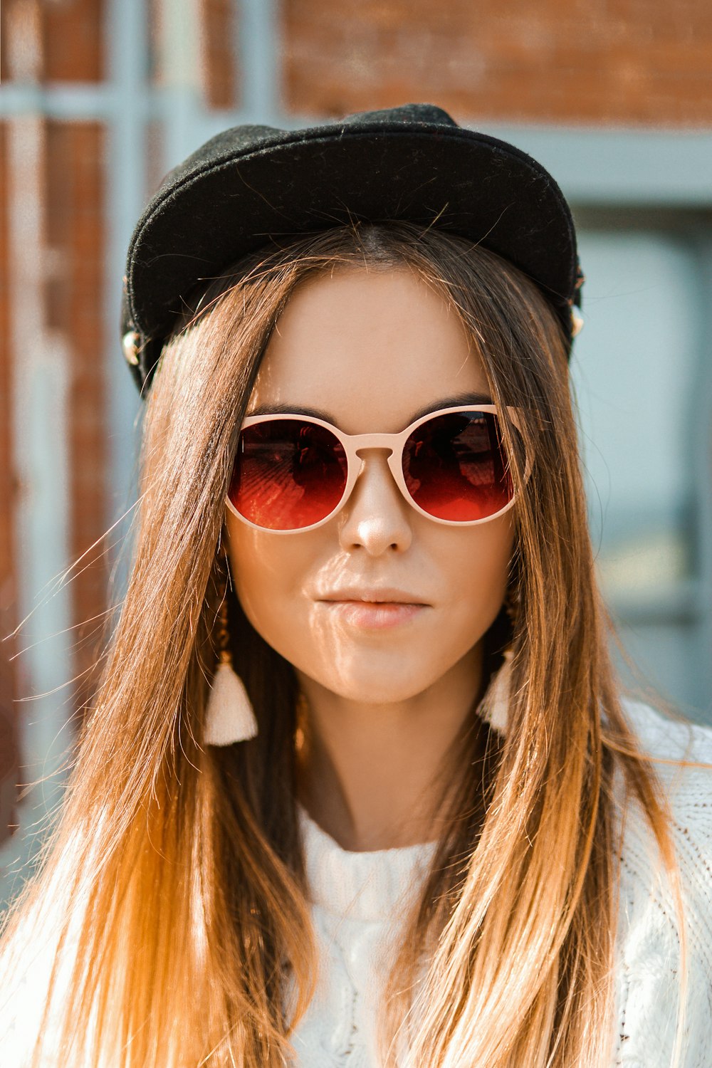 woman in white knit sweater and black fitted cap