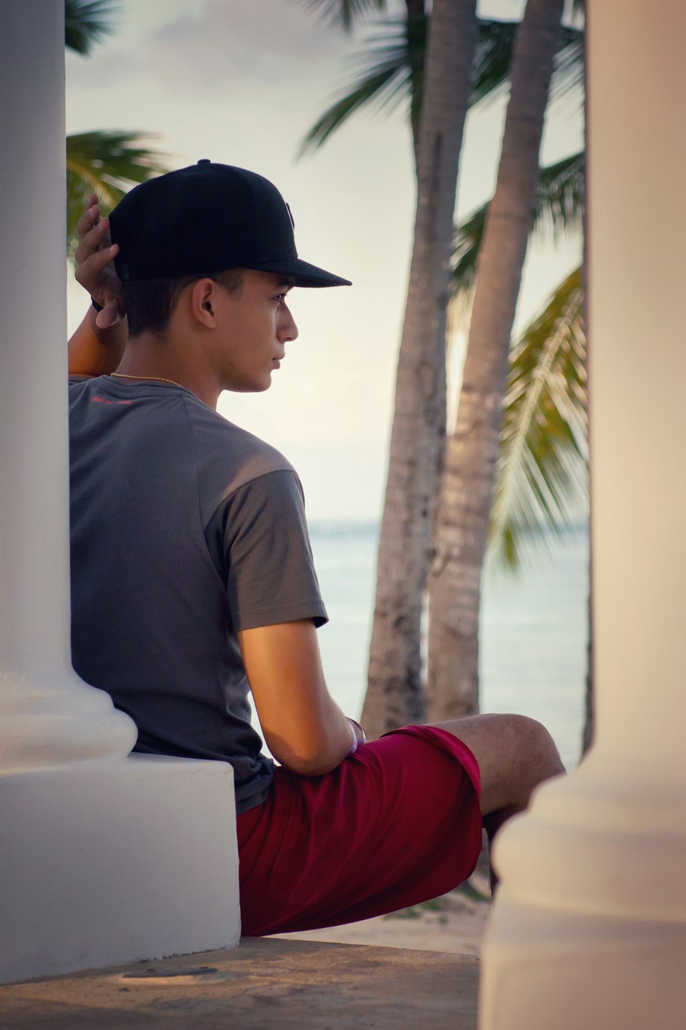 shallow focus of a man leaning on white pillar