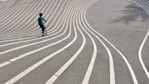 boy playing kick scooter on gray concrete pavement