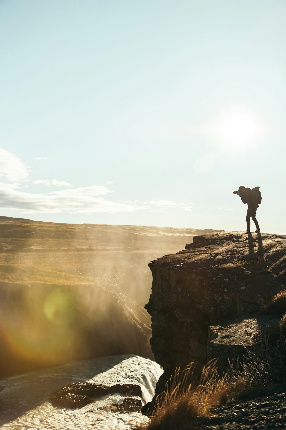 man standing on brown rocky mountain during daytime