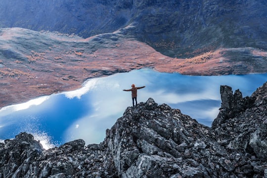 man standing near cliff in Besseggen Norway