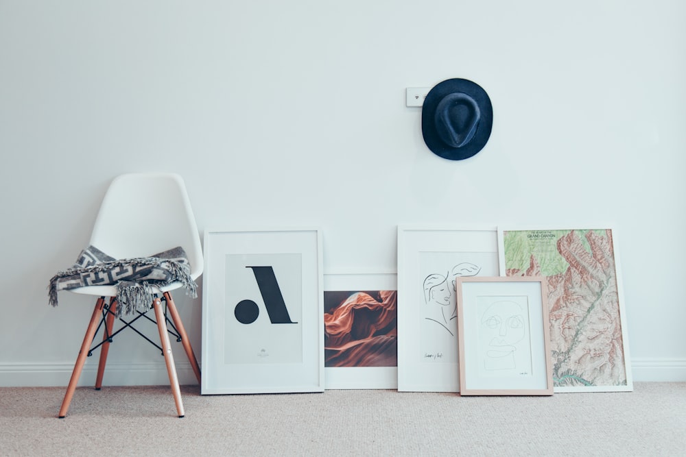 white chair beside five paintings