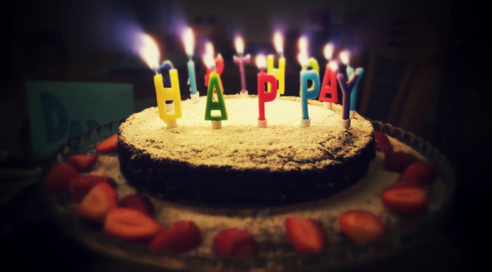 촛불이 켜진 둥근 생일 축하 케이크