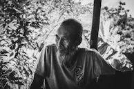 A candid portrait of an elderly Nicaraguan man sharing stories under a shaded tree.