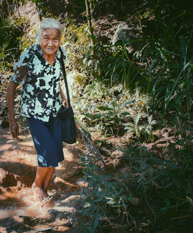 A joyful woman in her 50s walking confidently wearing flexipiel sandals on a cobblestone street.