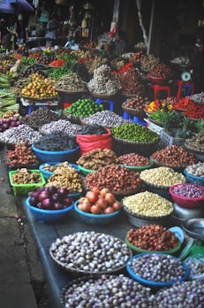 Fresh fruits and vegetables stacked in baskets at a bustling market stall.