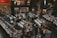 A vintage-style record store filled with rows of vinyl records and CDs. People are browsing through the music collections, with walls adorned with posters and album art. The setting appears spacious, with a cozy and nostalgic ambiance.