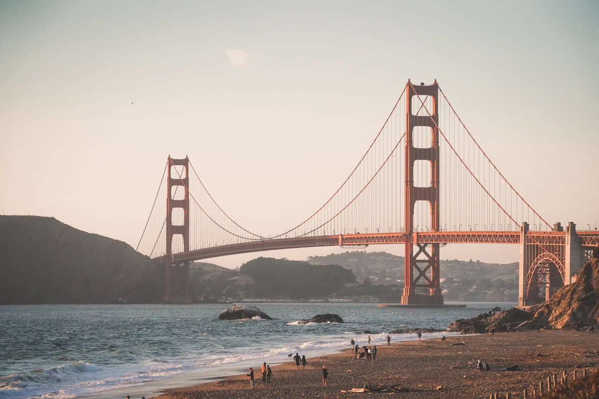 San Francisco'da Golden Gate Köprüsü manzarası önünde yürüyen insanlar