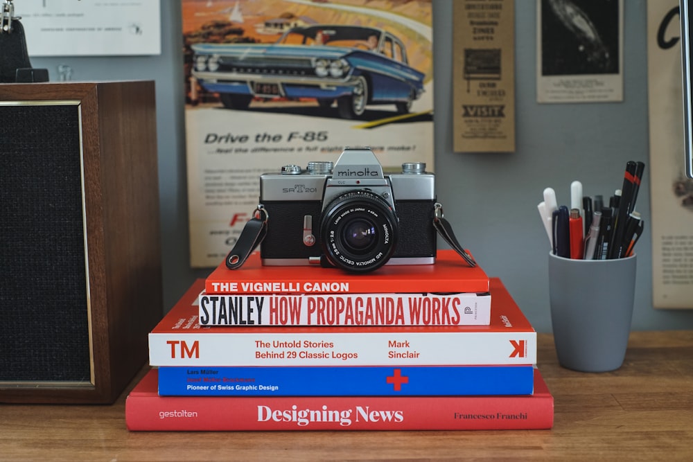 gray and black film camera on top of softbound books