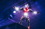 A futuristic digital avatar performing on a neon-lit stage.