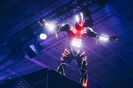 A futuristic digital avatar performing on a neon-lit stage.