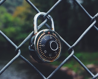 black and gray code padlock anchored on chain-link fence selective focus photo