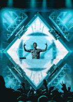 DJ mixing tracks with a lively audience waving hands in the air.