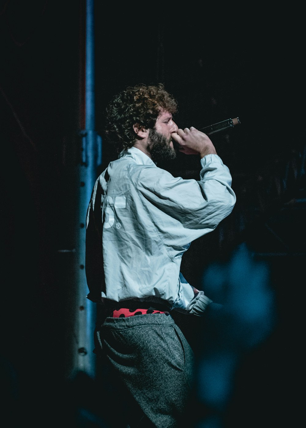 man holding cordless microphone on stage