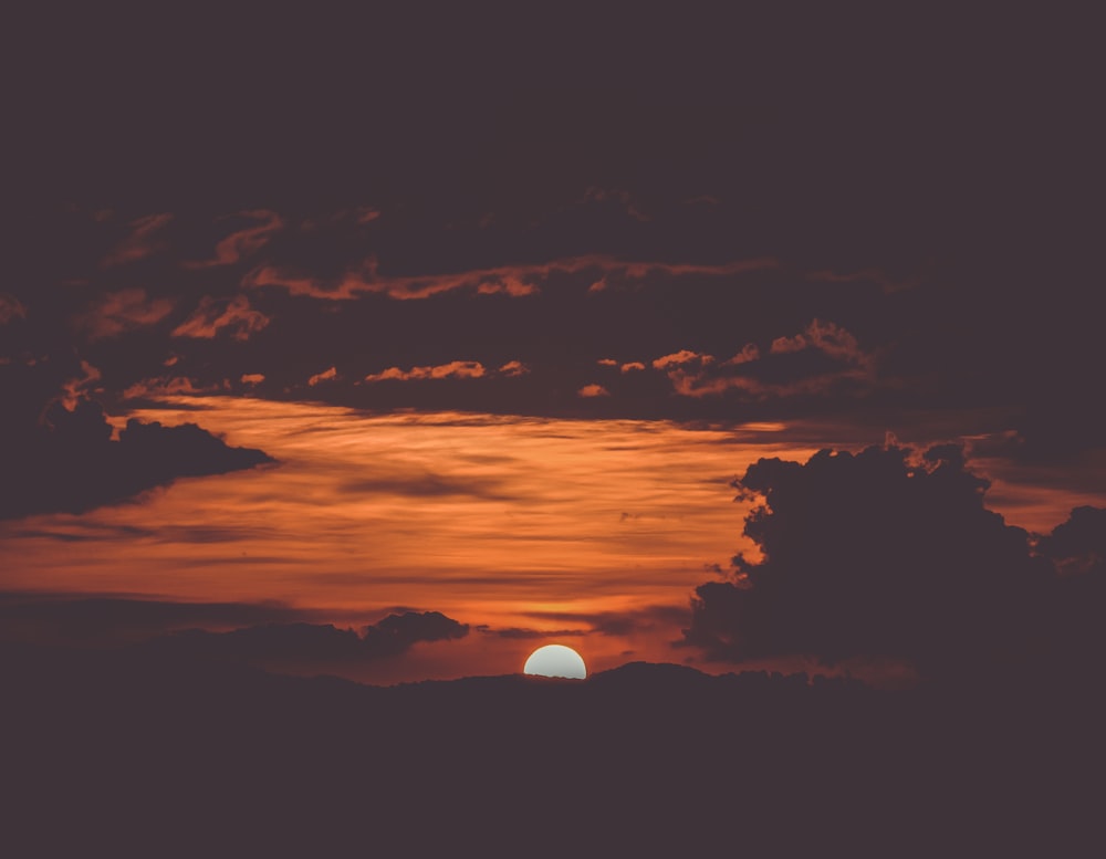 photo of sun setting beyond the horizon