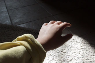 A hand reaching out to steady themselves after tripping over a loose rug.