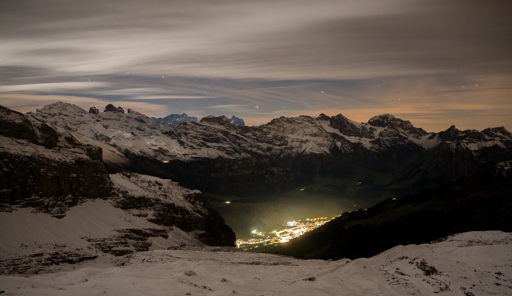 montanha coberta de neve sob o céu branco e cinza durante o dia