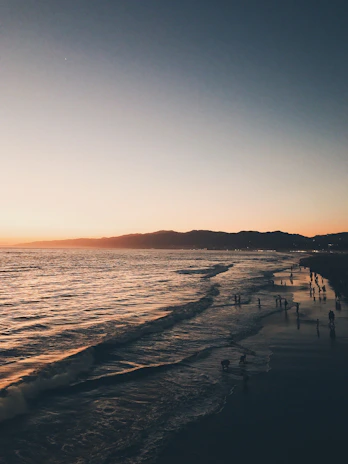A scenic beach sunset with travelers enjoying the view and local snacks.
