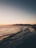 A scenic view of a tranquil beach at sunset.