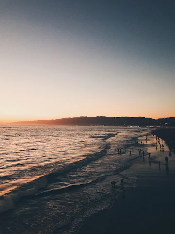 A scenic beach sunset with travelers enjoying the view.