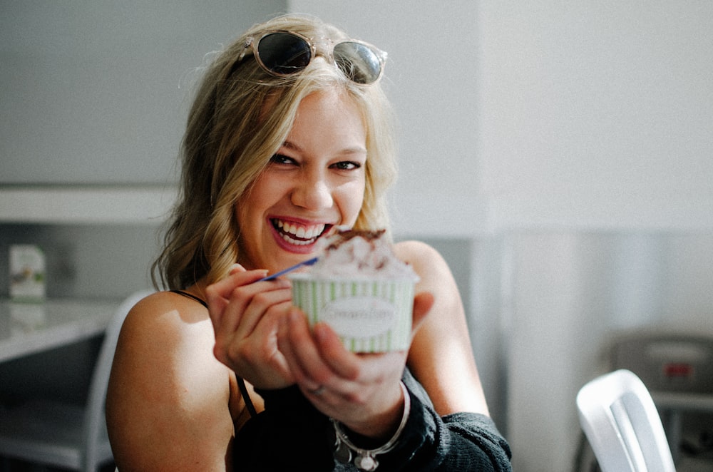 woman in black top holding disposable cup