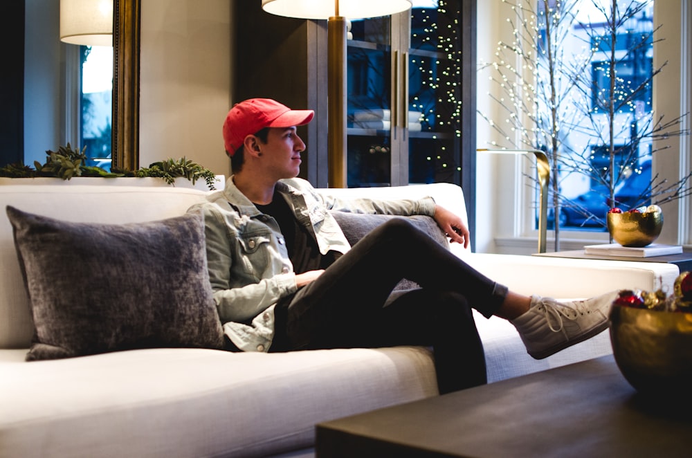 man in gray jacket sitting on couch