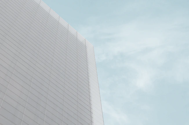 A serene facade of a government building featuring strong grids and minimalistic architectural elements in warm grey tones.