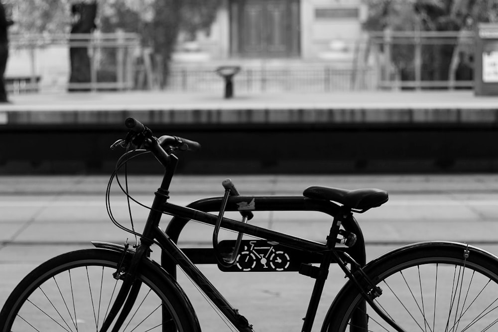 grayscale photography of bicycle lock on bike rack