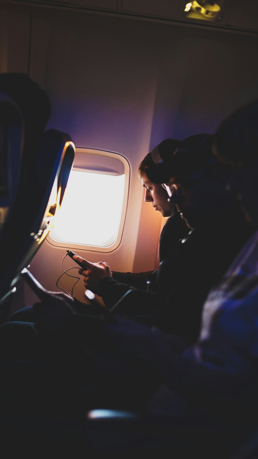 飛行機の中で音楽を聴く3人の写真
