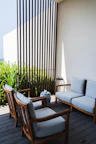 Inviting seating area in the garden with wooden chairs and soft cushions.