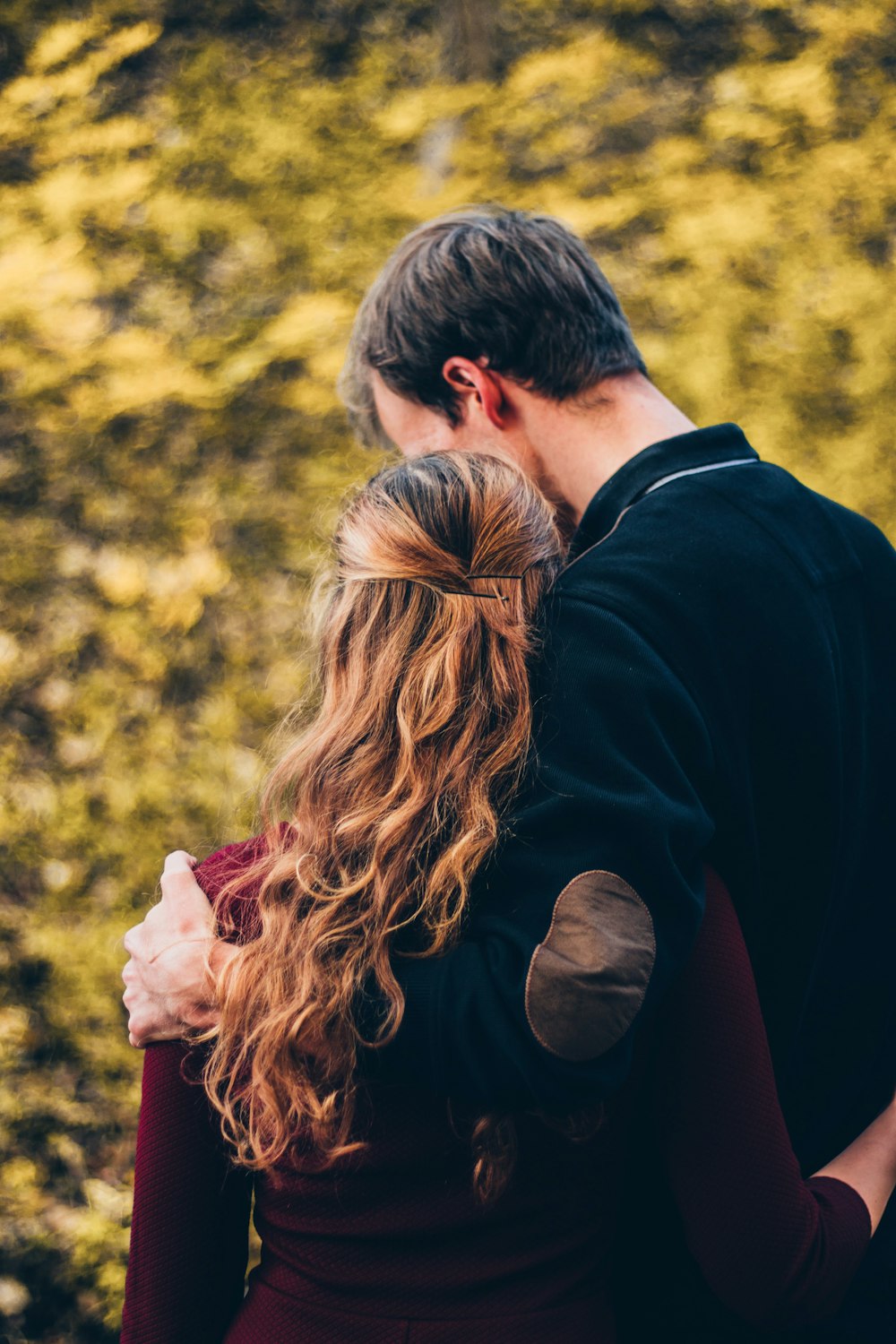 woman and man standing beside tree at daytime