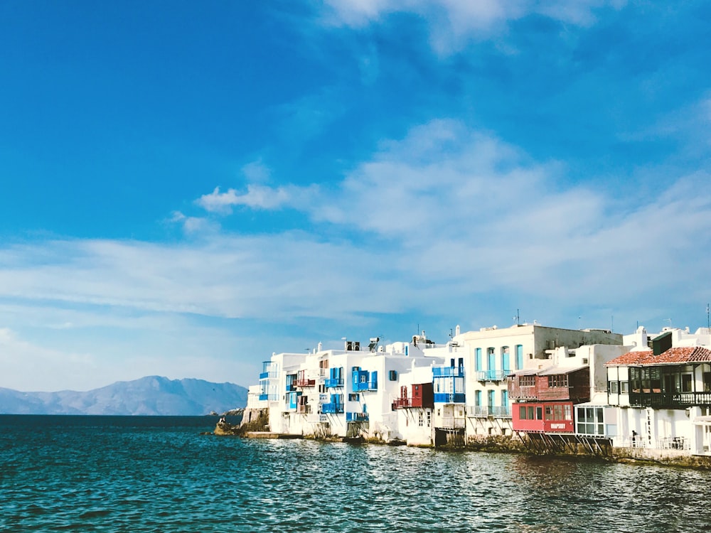 white concrete houses near body of water