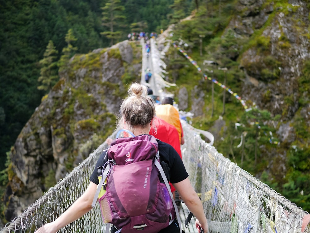 people on hanging bridge during daytime