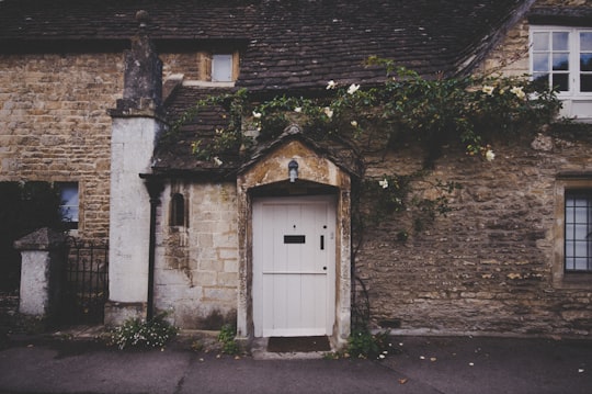 landscape photo of closed white door in Castle Combe United Kingdom