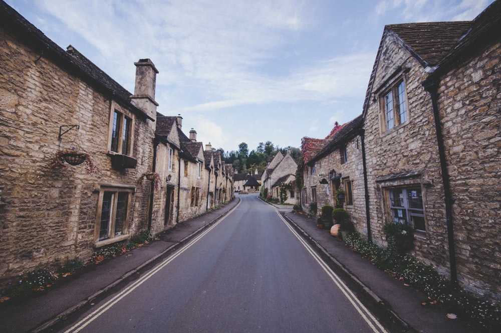 concrete road between brick wall buildings