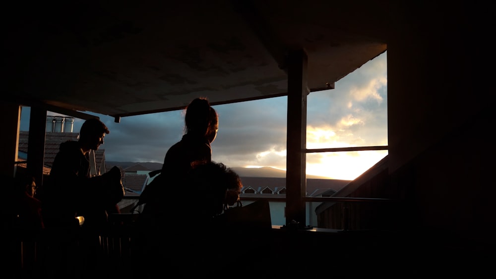 silhouette of two persons standing near the window