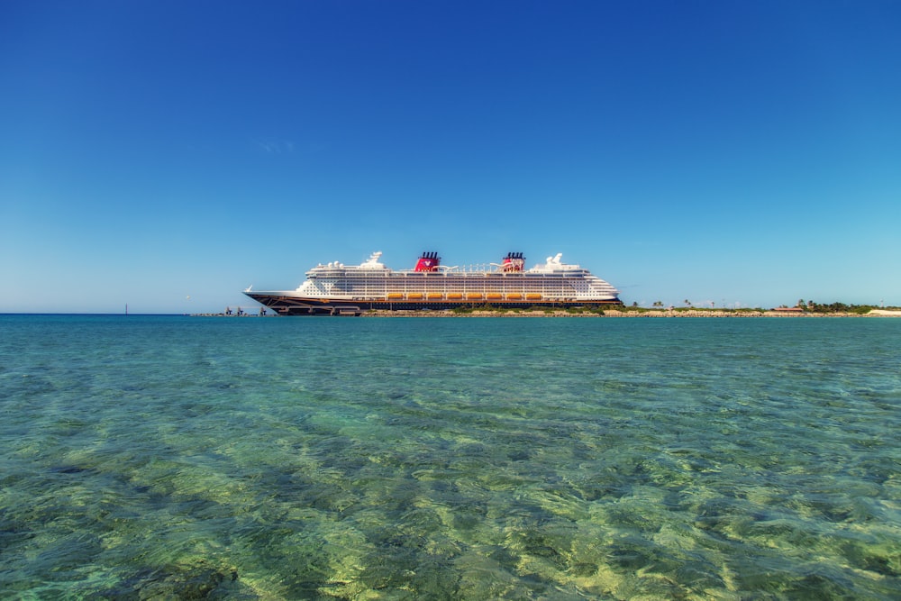 navio de cruzeiro branco e preto na água sob o céu azul durante o dia