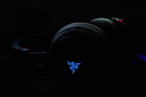 A stylish pair of wireless headphones with a glowing control panel in the background.