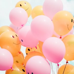 low-angle photo of pink and orange balloons