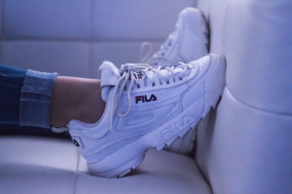 woman wearing white Fila shoes
