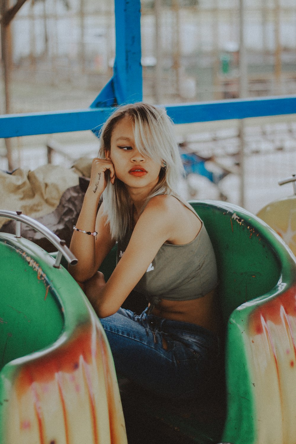 woman in gray crop top sitting on green chair