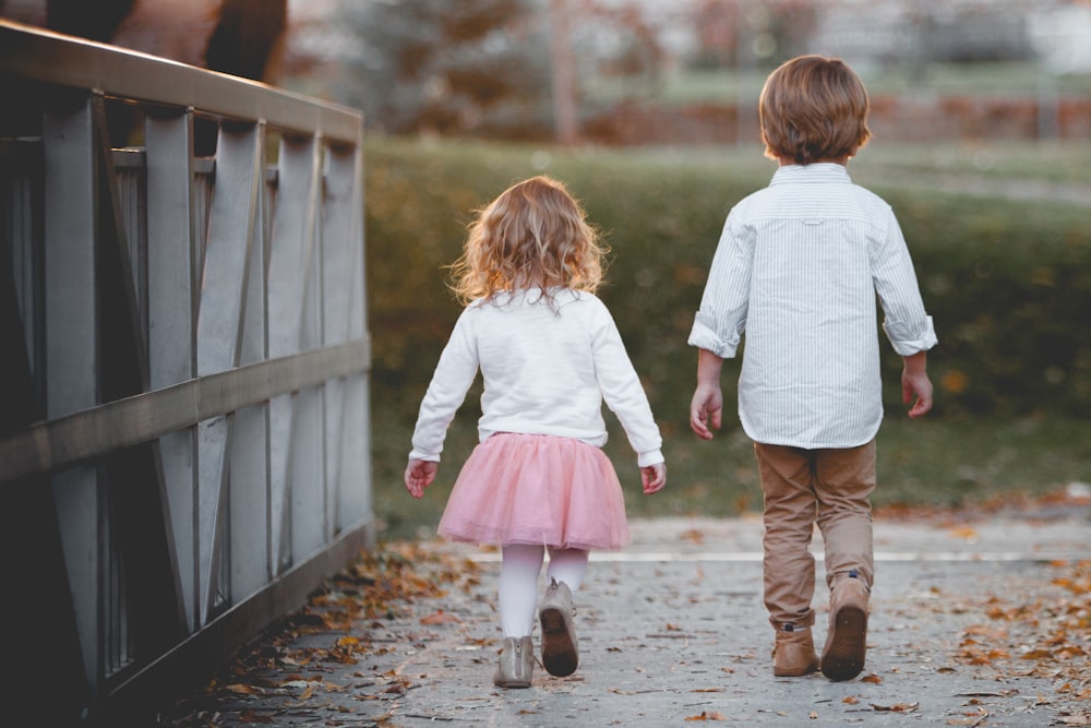 boy beside girl walking near railing